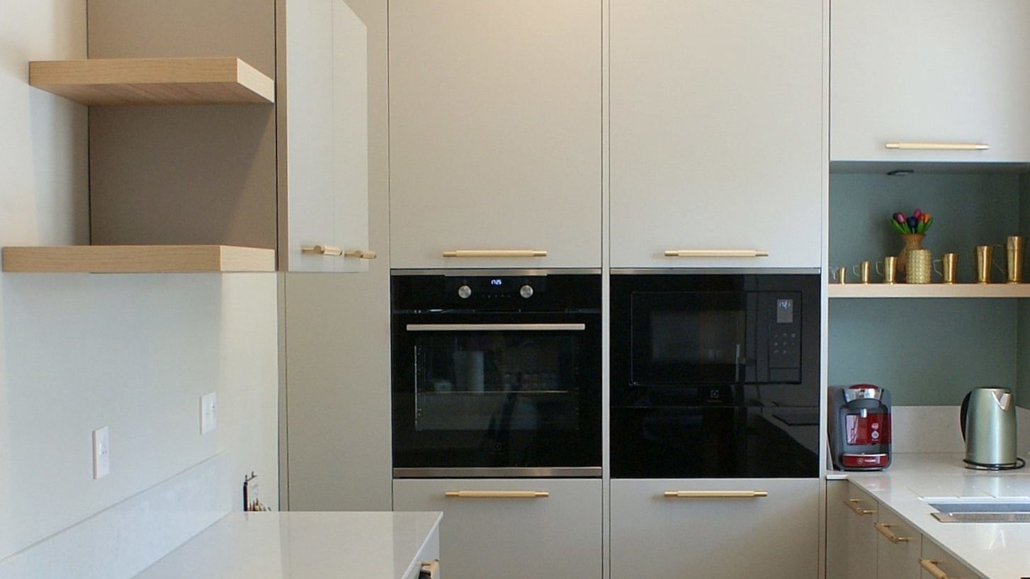 Cuisine contemporaine aux façades beige grisé et poignées dorées