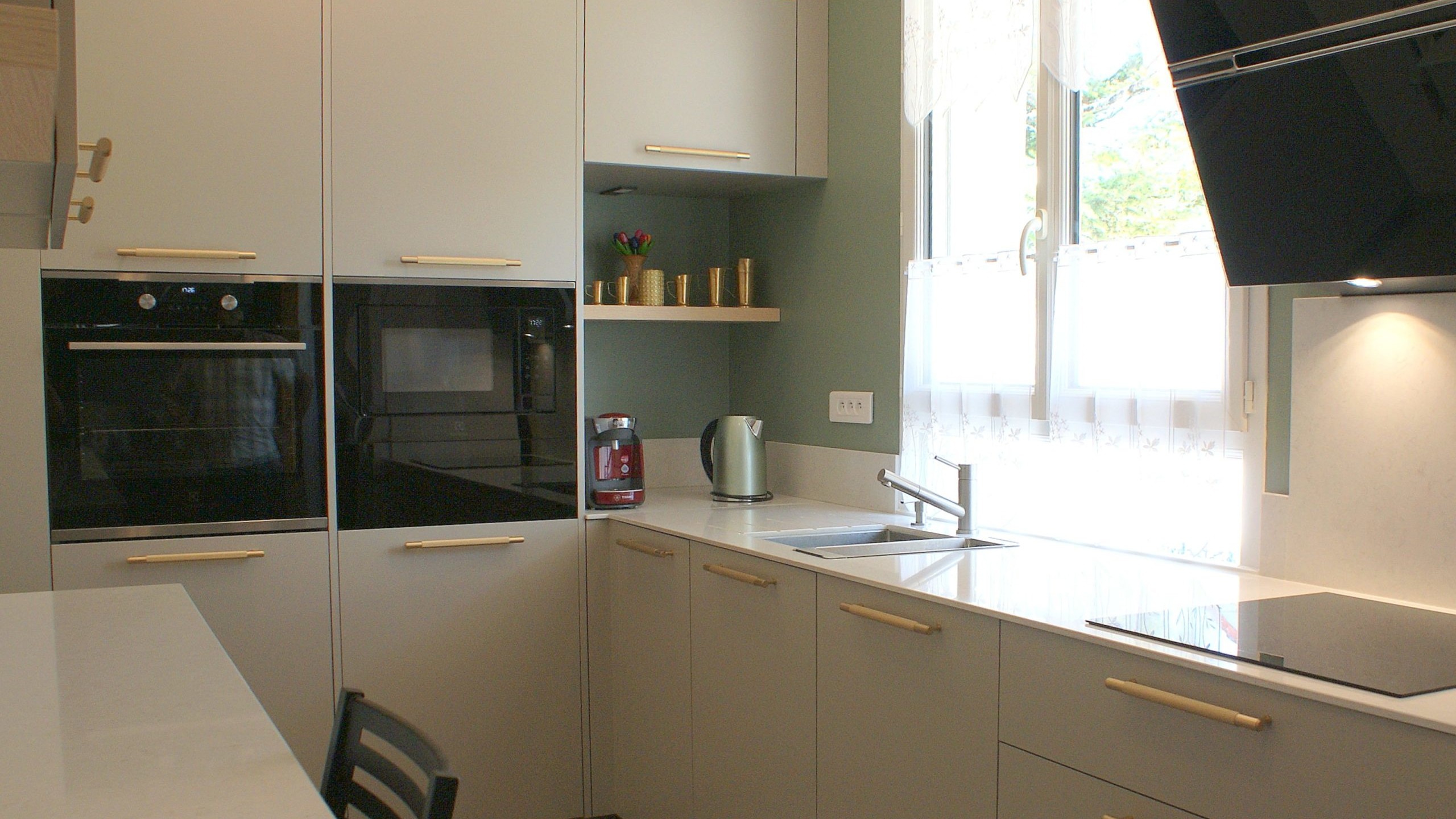 Cuisine contemporaine aux façades beige grisé et poignées dorées