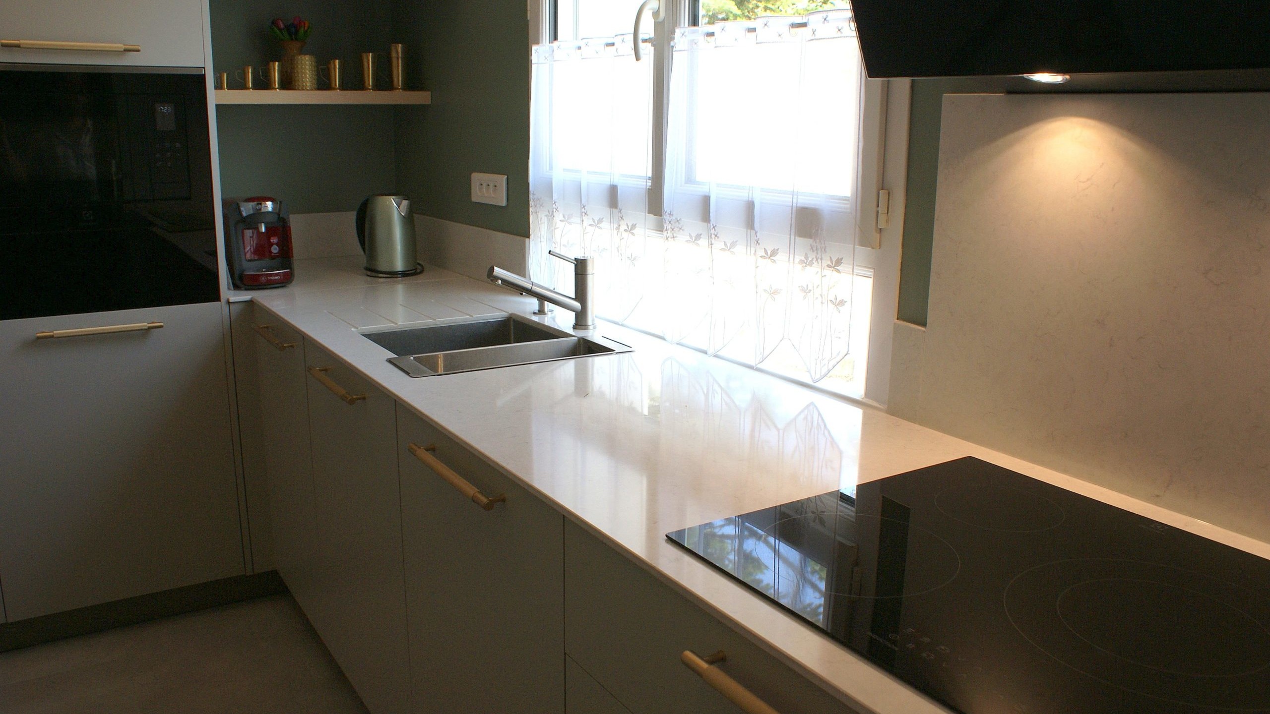 Cuisine contemporaine aux façades beige grisé et poignées dorées