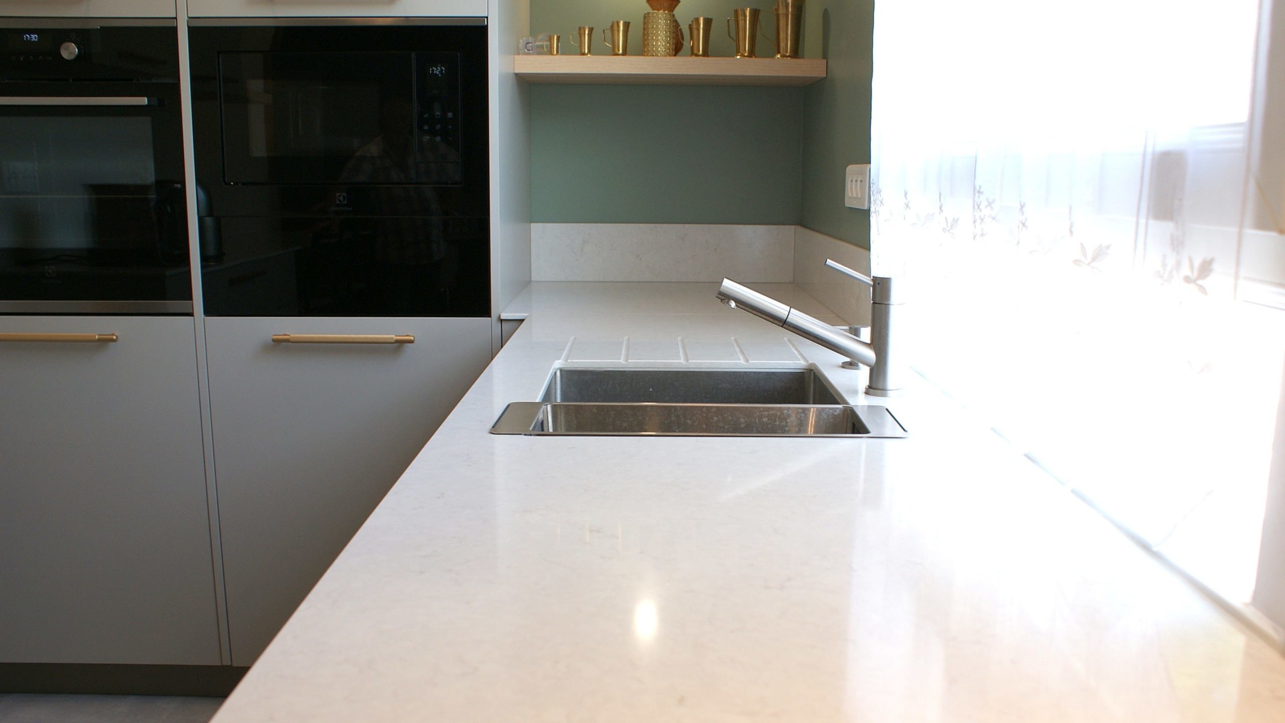 Cuisine contemporaine aux façades beige grisé et poignées dorées