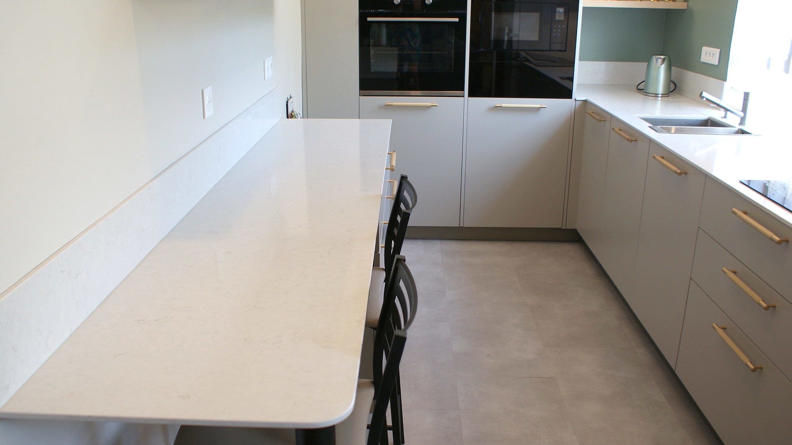 Cuisine contemporaine aux façades beige grisé et poignées dorées