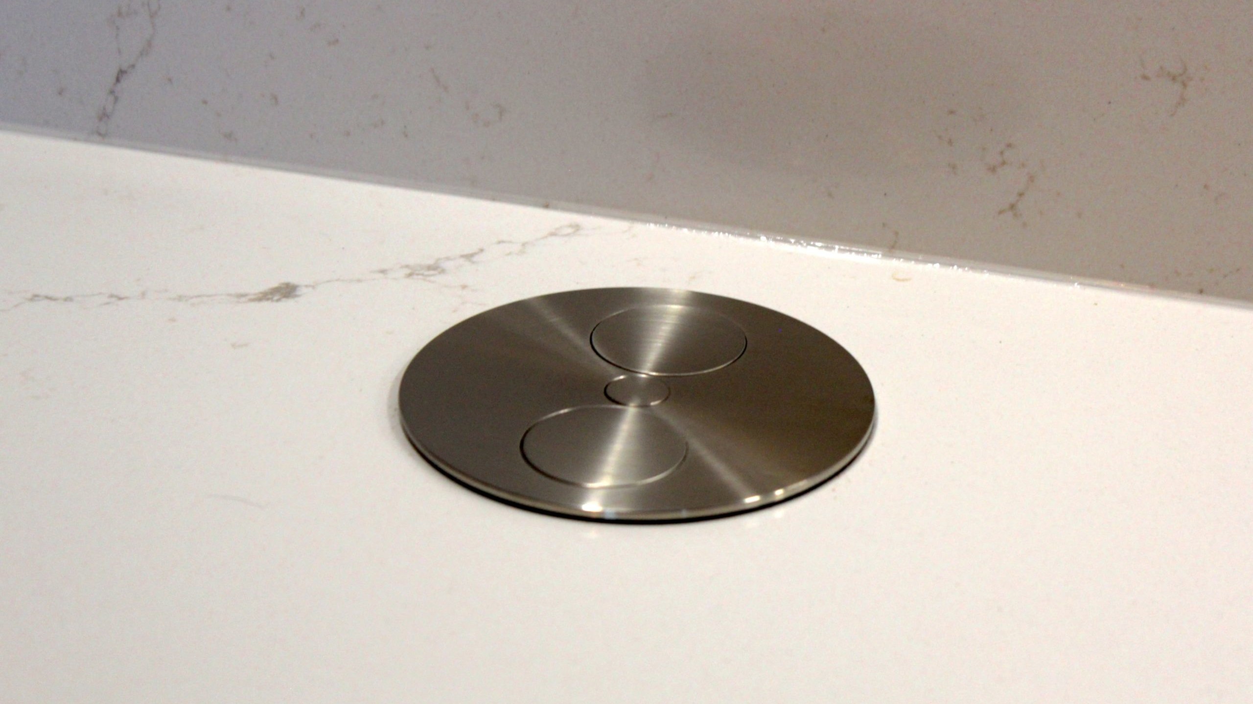 Cuisine moderne en placage bois clair avec plan de travail en quartz blanc, intégrée dans un intérieur en pierre à Nanteuil-en-Vallée.